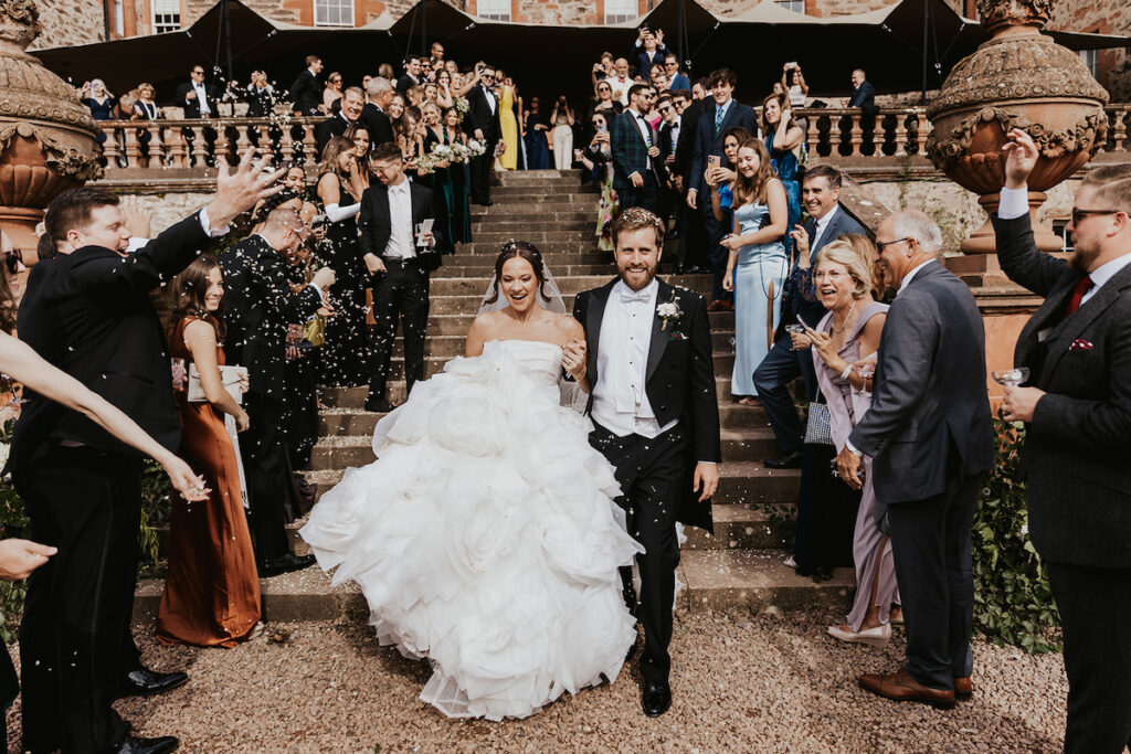 Bride and groom walking down the steps of a Scottish castle